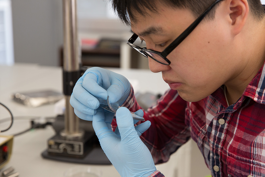 Student inspecting biomedical device