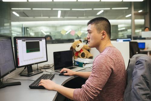 Graduate student exploring computer models on a screen in the lab