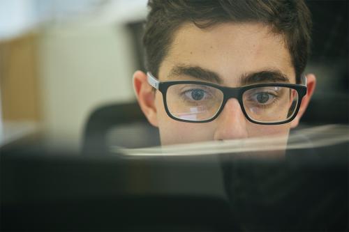 person looking over a laptop screen